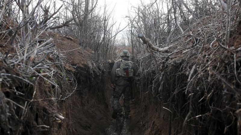 A Ukrainian serviceman walks in a trench as he stands at his post on the frontline with Russia-backed separatists near the town of Zolote, in the Lugansk region, on April 9, 2021. STR / AFP