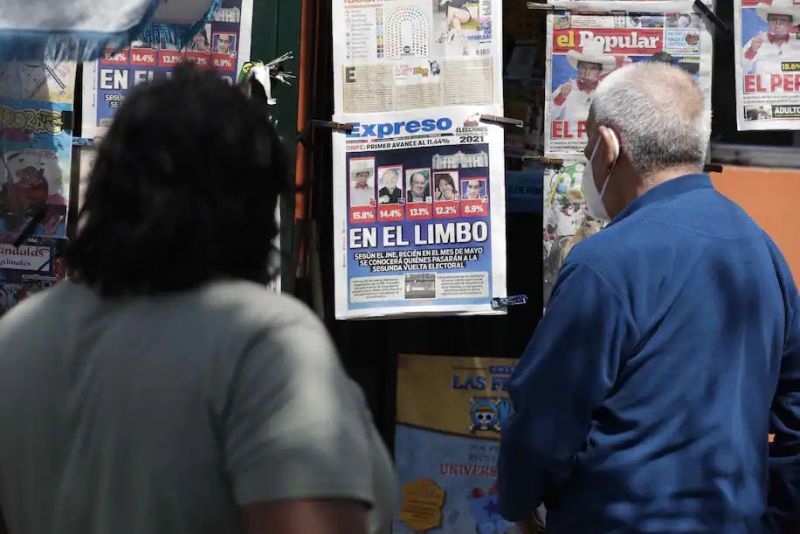 Dos personas observan las portadas de los periódicos con los resultados de las elecciones generales, en Lima, Perú, el 12 de abril de 2021. (Paolo Aguilar/EPA-EFE/Shutterstock)