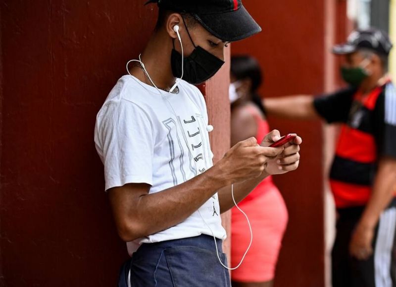 A young man uses his phone on a street in Havana this month. (Yamil Lage/AFP)