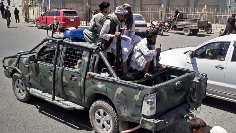 Taliban fighters drive an Afghan government security force vehicle through a street in Kandahar on 13 August 2021. AFP