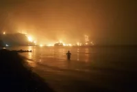 En esta foto de archivo del 6 de agosto de 2021, un hombre observa cómo los incendios forestales se acercan a la playa de Kochyli en la isla de Evia, al norte de Atenas, Grecia. (AP Photo/Thodoris Nikolaou)