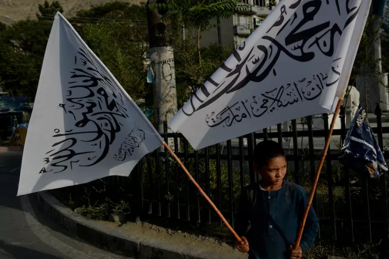 A boy carries Taliban flags for sale in Kabul on Sunday. (Hoshang Hashimi/AFP/Getty Images)