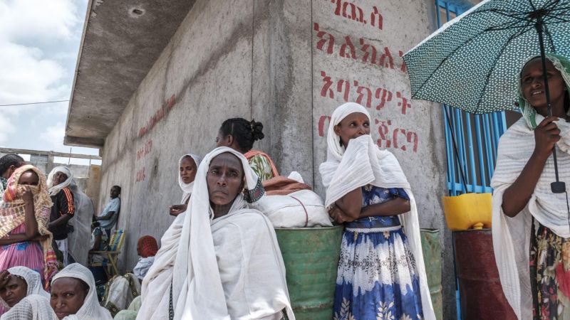 Women wait during a food distribution organized by the Amhara government near the village of Baker, 50 km southeast of Humera, in the Tigray Region of Ethiopia, on July 11, 2021. EDUARDO SOTERAS / AFP