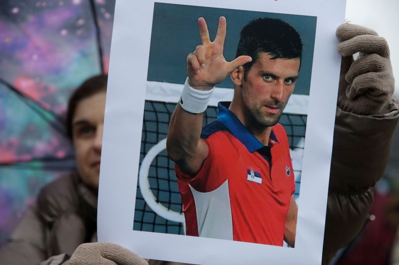 Un fan del tenista serbio Novak Djokovic sostiene una foto durante una protesta de apoyo en Belgrado, Serbia, el 8 de enero de 2022. El deportista no se quiere vacunar contra el COVID-19 y está por ser deportado y no jugar el Abierto de Australia. (Andrej Cukic/EPA-EFE/Shutterstock)