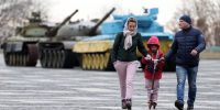 A family visits the Motherland Monument in Kyiv on 21 February 2022 as tensions between pro-Russia separatists and the Ukrainian army increase. Photo by Ali Atmaca/Anadolu Agency via Getty Images.