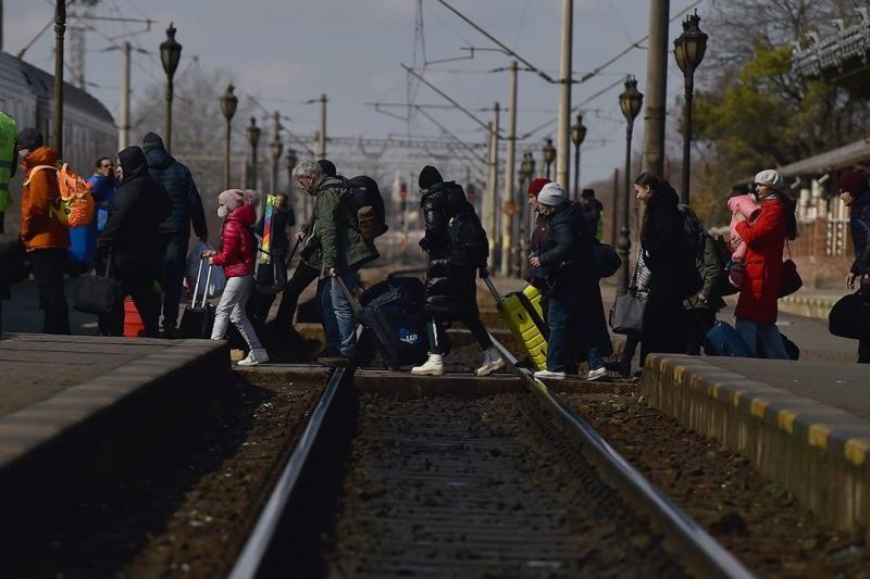  Refugees walk across train tracks to board a train to Bucharest at Suceava train station after fleeing Ukraine to the Siret border crossing in Romania, following Russia's invasion of Ukraine, in Suceava, Romania, March 17, 2022. REUTERS / Clodagh Kilcoyne 