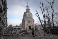 A Ukrainian serviceman takes a photograph of a damaged church in Mariupol on March 10. (Evgeniy Maloletka/AP)
