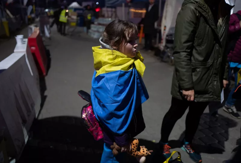 Anastasia, 8, wraps herself in a Ukrainian flag at the border crossing in Medyka, Poland, on March 23. (Kacper Pempel/Reuters)
