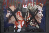 Pintadas sobre la imagen de Macron y Le Pen tras una manifestación en París, el 18 de abril.Francois Mori (AP)