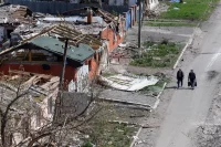 Walking near damaged buildings in Mariupol, Ukraine, April 2022. Alexander Ermochenko / Reuters