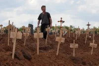 Walking amid newly-made graves outside Mariupol, Ukraine, May 2022. Alexander Ermochenko / Reuters