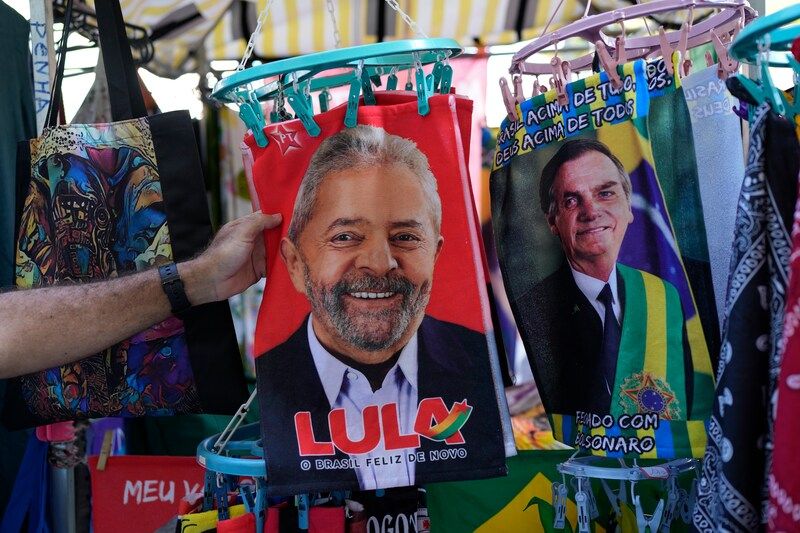 A vendor in Rio de Janeiro sells towels featuring the images of presidential candidate Luiz Inácio Lula da Silva, left, and Brazilian President Jair Bolsonaro. (Silvia Izquierdo/AP)