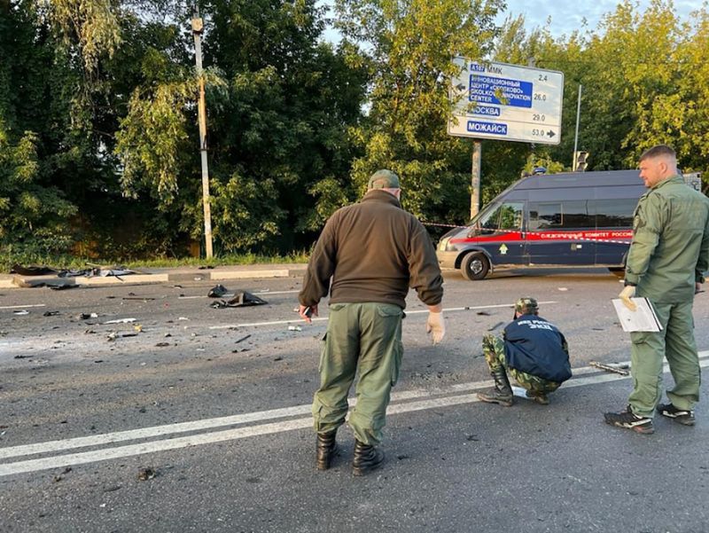 Investigators work at the site of a car bombing that killed Daria Dugina, daughter of Russian hard-liner Alexander Dugin, outside Moscow. (Investigative Committee of Russia/AFP) 