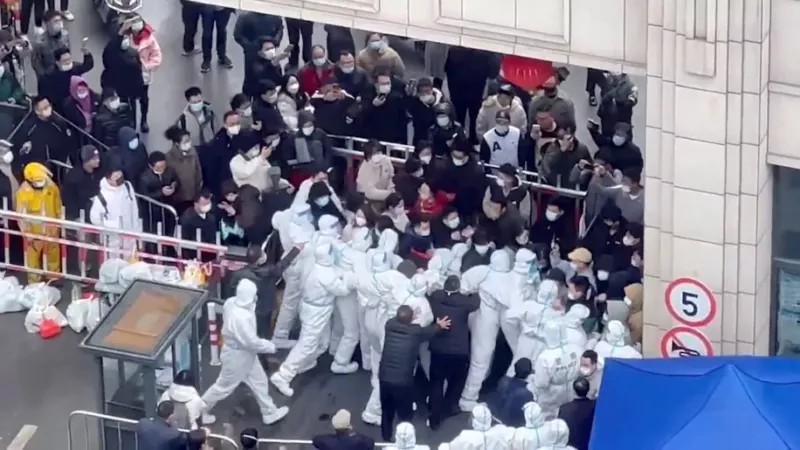 Residents confront workers in protective suits who are blocking the entrance to a residential compound in Shanghai in this still image obtained from a social media video released Nov. 30. (Reuters) (Video Obtained By Reuters/via REUTERS)