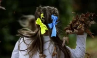 A young girl with Ukrainian coloured bows in her hair at a celebration for Ukraine independence day in Chichester, 27 August 2022. Photograph: Frank Augstein/AP