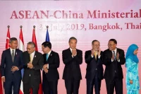 Chinese Foreign Minister Wang Yi, center, claps after posing for a group photo during the ASEAN-China Foreign Ministers Meeting in Bangkok on July 31, 2019. (Gemunu Amarasinghe/AP)
