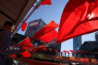 Chinese citizens waving national flags in Beijing, October 2021. Thomas Peter / Reuters