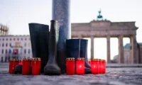 Rubber boots and candles in front of the Brandenburg Gate during a nationwide farmers' strike, in Berlin, Germany, 9 January 2024. Photograph: Clemens Bilan/EPA