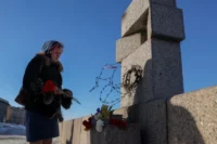 Una mujer depositaba el lunes flores en recuerdo de Alexéi Navalni, en el monumento a las víctimas de la represión política en San Petersburgo.REUTERS
