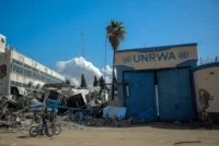 People walk past the damaged headquarters of the United Nations Relief and Works Agency for Palestine Refugees (UNRWA) in Gaza City on Feb. 15. AFP via Getty Images