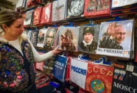 An employee presents t-shirts with images of Vladimir Putin at a gift shop, Moscow, 2018. Alexander Nemenov/AFP/Getty Images
